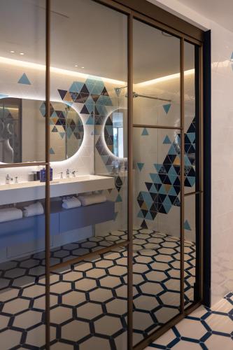a bathroom with glass doors and a tile floor at Château Rose Golfe de Saint Tropez-Grimaud in Grimaud