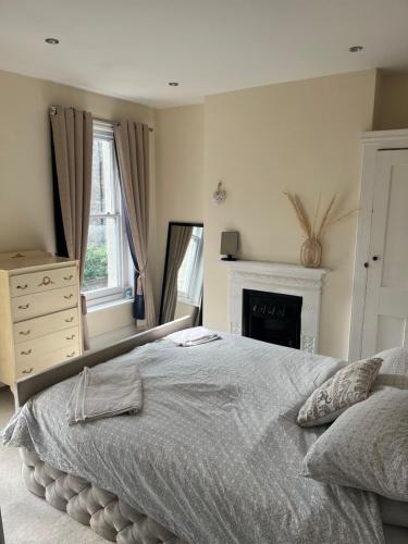 a bedroom with a large bed and a fireplace at Victorian Town House in the Heart of Dover in Dover