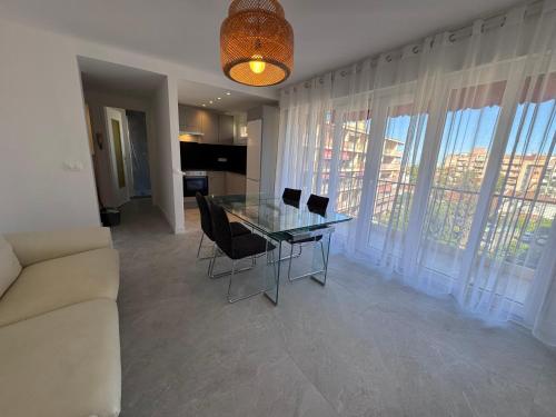 un salon avec une table en verre et des chaises dans l'établissement Appartement proche Monaco, à Roquebrune-Cap-Martin