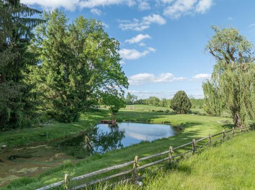 a pond in a field next to a fence at The Lodge at Fields of Home in Millersburg