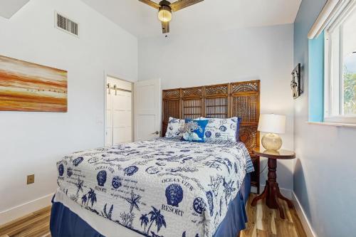 a bedroom with a blue and white bed and a window at Lookout at Lorelane in Key Largo
