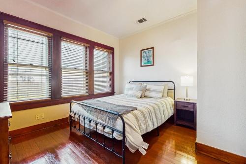 a bedroom with a bed and two windows at The Historic Garison House in Buda