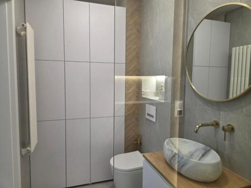 a bathroom with a sink and a mirror at Apartament Kwiatowy DeLux in Sanok