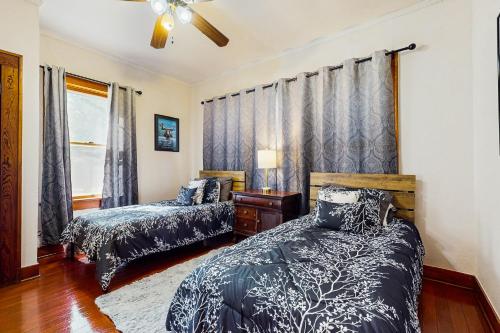 a bedroom with two beds and a ceiling fan at The Historic Garison House in Buda