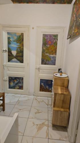 - deux portes dans une pièce ornée de peintures murales dans l'établissement Charmant appartement ensoleillé à deux pas de Monaco, à Beausoleil
