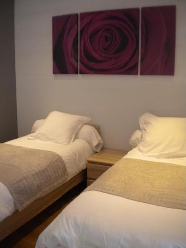 2 Betten in einem Zimmer mit Wandgemälde in der Unterkunft Le Moulin in Argelès-Gazost