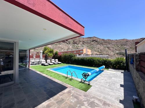 a swimming pool with a slide in a house at Estrella Del Sur Tauro Ocean Wiew Heated Pool in Mogán