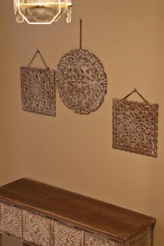 a wall with a wooden shelf and a chandelier at Themis - Θέμις Apart Hotel in Loutra Edipsou