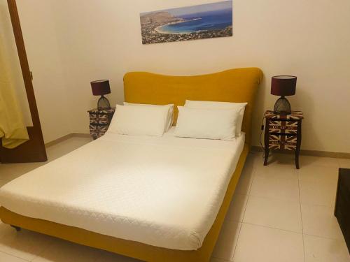 サンタ・フラーヴィアにあるLa casa dei Nonniのベッドルーム1室(白いシーツとランプ2つ付)