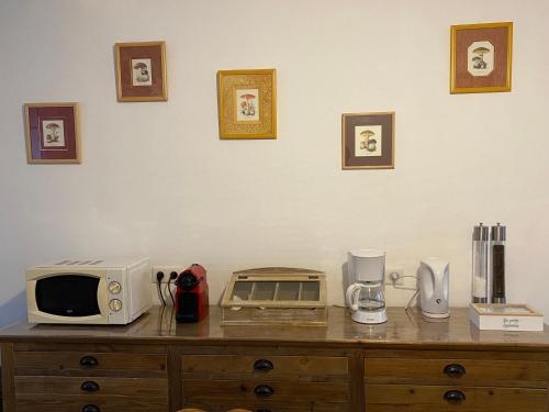a microwave sitting on top of a wooden dresser at maison au calme avec piscine chauffée in Bucy-le-Long