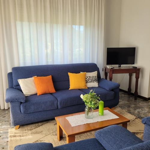 a living room with a blue couch with colorful pillows at Casa Eliana Mountain Lake Iseo Hospitality in Sovere