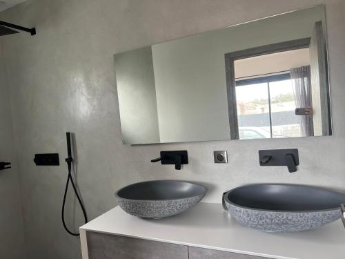 une salle de bain avec deux lavabos et un miroir dans l'établissement Maison 2 chambres, à Figari