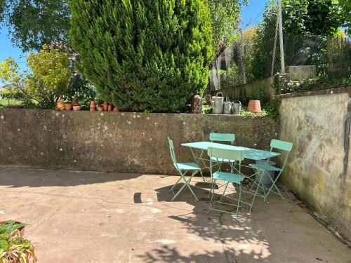 a table and chairs sitting next to a concrete wall at La Chambre de Marie in Bouxwiller