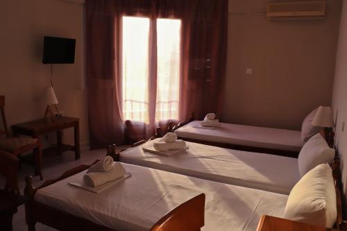 two beds in a hotel room with towels on them at Themis - Θέμις Apart Hotel in Loutra Edipsou