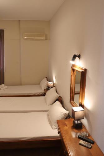 a small room with a bed and a mirror at Themis - Θέμις Apart Hotel in Loutra Edipsou