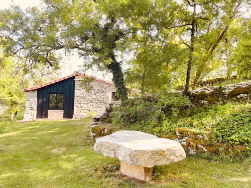 a stone bench sitting in front of a building at Mas de Méjas Gîte La Casaline in Calvignac