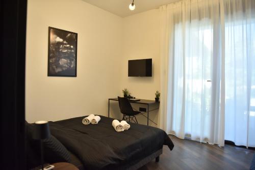a bedroom with a bed and a desk and a television at Rent Your Family Retreat in Novi Sad in Novi Sad
