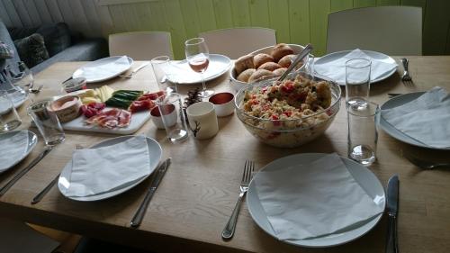 a wooden table topped with plates and a bowl of food at Skarsnuten Panorama 61, Hemsedal in Hemsedal
