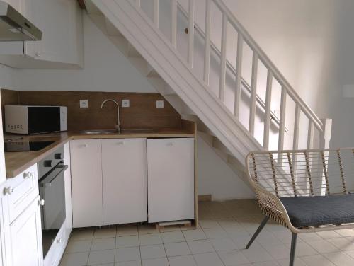une cuisine avec un évier et un escalier dans l'établissement La mouette rieuse, à Saintes-Maries-de-la-Mer