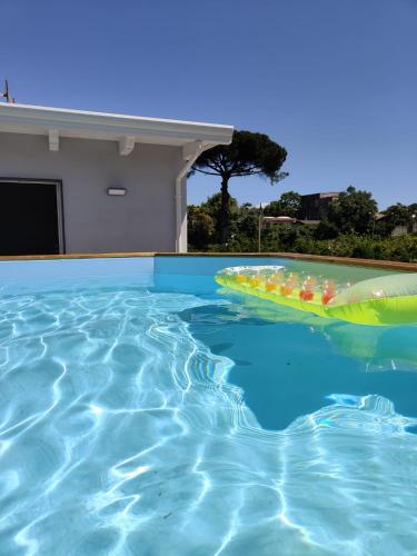 a swimming pool with a raft in the water at Villa Cola - Vesuvio Garden & Relax in Boscotrecase