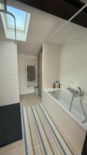 La grande salle de bains est pourvue d'une baignoire et d'une fenêtre. dans l'établissement Vue sur mer EPOUSTOUFLANTE, à Sausset-les-Pins