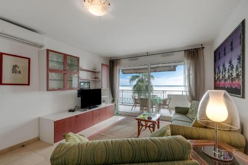 un salon avec un canapé et une télévision dans l'établissement Admiral Plaza Sea View - Happy Rentals, à Menton