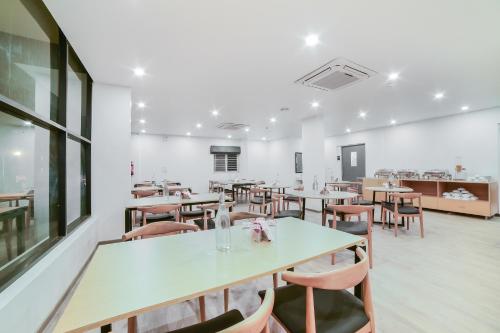 a restaurant with tables and chairs in a room at Townhouse Sarjapur Near Bellandur in Bengaluru