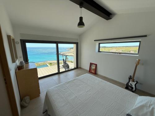 une chambre avec un lit et une vue sur l'océan dans l'établissement Vue sur mer EPOUSTOUFLANTE, à Sausset-les-Pins