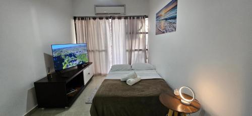 a bedroom with a bed and a flat screen tv at Beachfront Condo Large Apartament in Rio de Janeiro