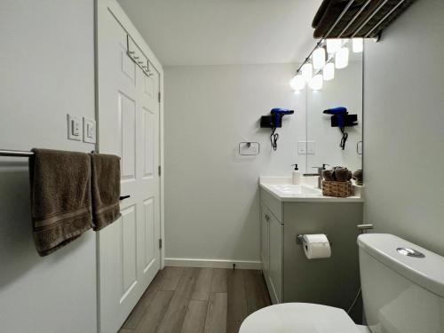 a white bathroom with a toilet and a sink at Urban Nest by Guest Expertise in Winnipeg