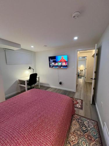 a bedroom with a bed and a desk and a tv at Urban Nest by Guest Expertise in Winnipeg