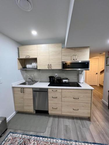 a kitchen with wooden cabinets and a sink and a stove at Urban Nest by Guest Expertise in Winnipeg