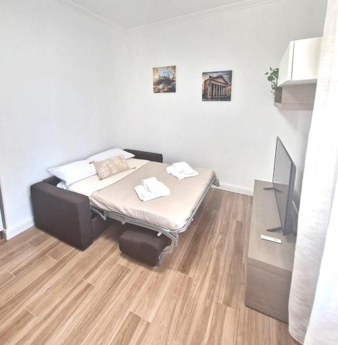 a small room with a bed and a television at Aura Station Ciampino in Ciampino