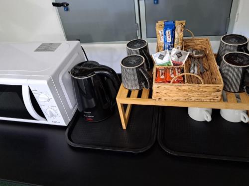 a counter with a microwave and a table with a coffee maker at Penzion Škubánek in Mladá Boleslav