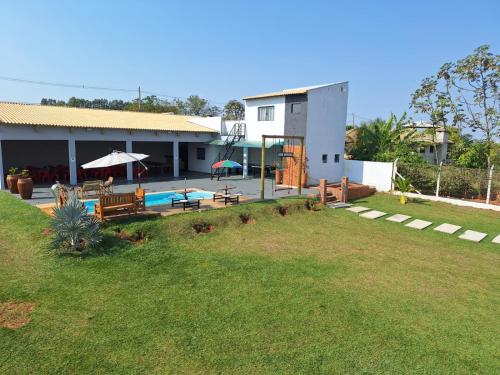 a house with a patio and a swimming pool at Chácara Império dourado in Álvares Machado