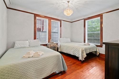 two beds in a room with two windows at Sinatra House Down Walk to Pleasure Pier and Fun in Galveston