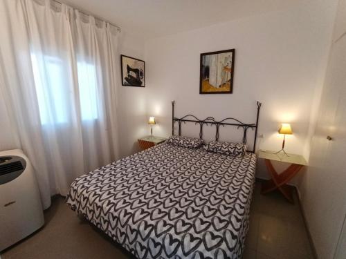 a bedroom with a black and white bed and a window at Puerto Rico 6 in Empuriabrava