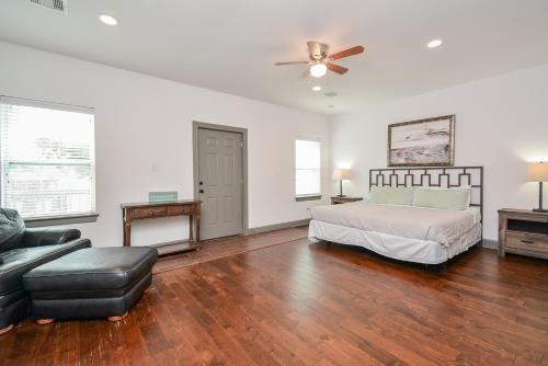a bedroom with a bed and a couch and a ceiling fan at Welcome to Coastal Serenity – your perfect vacation retreat by the sea in Galveston