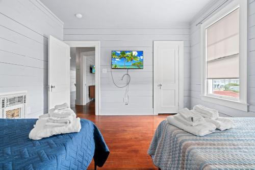 a bedroom with two beds with towels on them at Sinatra House: Mardi Gras Parade Route in Galveston
