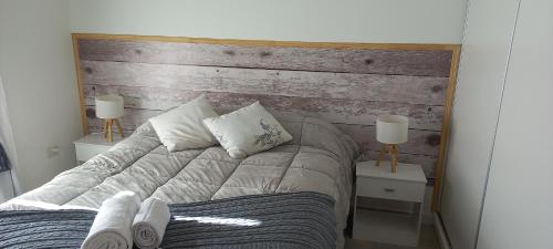 a bedroom with a wooden headboard and a bed at Ameli in Neuquén