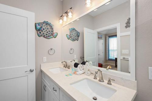 a bathroom with a sink and a large mirror at Welcome to Arandel With A Lovely Ocean View in Galveston