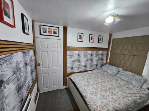 a small bedroom with a bed and a door at Femros Apartments, 15mins to city center. in Smethwick