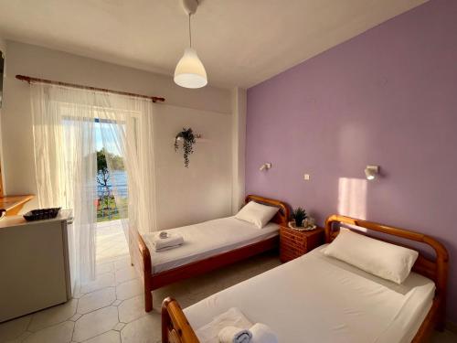 a room with two beds and a window at Physis Seaside Living in Preveza