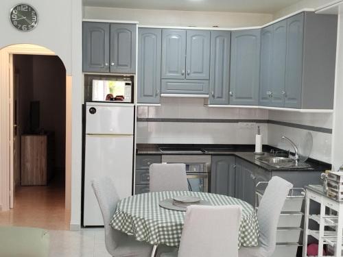 a kitchen with blue cabinets and a table and chairs at Nomito in San Juan de los Terreros