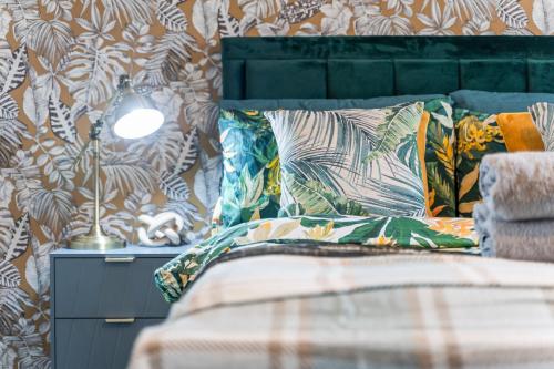 a bedroom with a bed with colorful pillows at #16 Stunning 3 Bed home- near Core Theatre -Sleeps 7- Perfect for contractors and families - Free parking in Marston Green