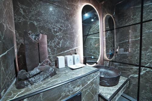 une salle de bain avec un lavabo et un miroir dans l'établissement Chez Le Petit Potter Escape Game et Pièce Secrète en Option, à Nancy