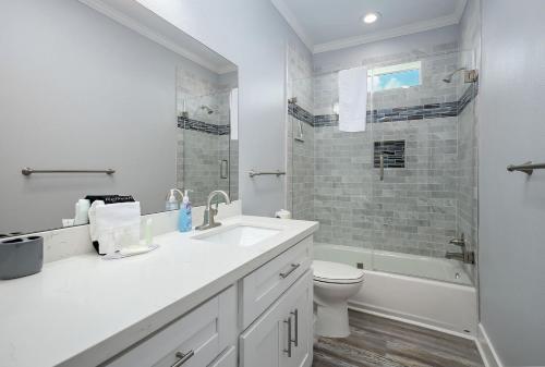 a white bathroom with a sink and a toilet at Seagle Shack Gulf Views From this New 42 in Bay Harbor in Galveston