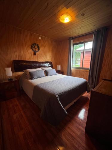 Cabañas Rukaparra في Pinto: غرفة نوم بسرير كبير ونافذة