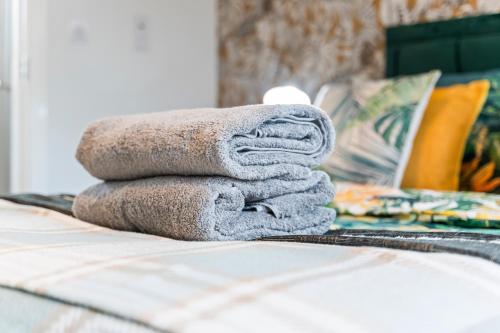 a pile of towels sitting on top of a bed at #16 Detached Stunning Lux 3 Bed home Parking NEC in Marston Green