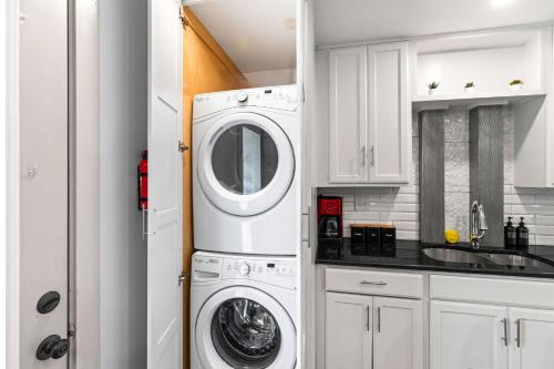 a white kitchen with a washer and dryer at Cool Vibes Music Capital SoCo Townhome! in Austin
